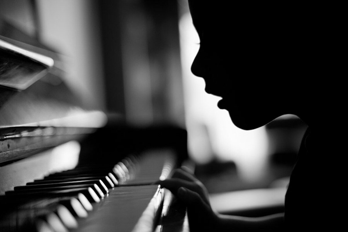 silhouette of a child playing piano