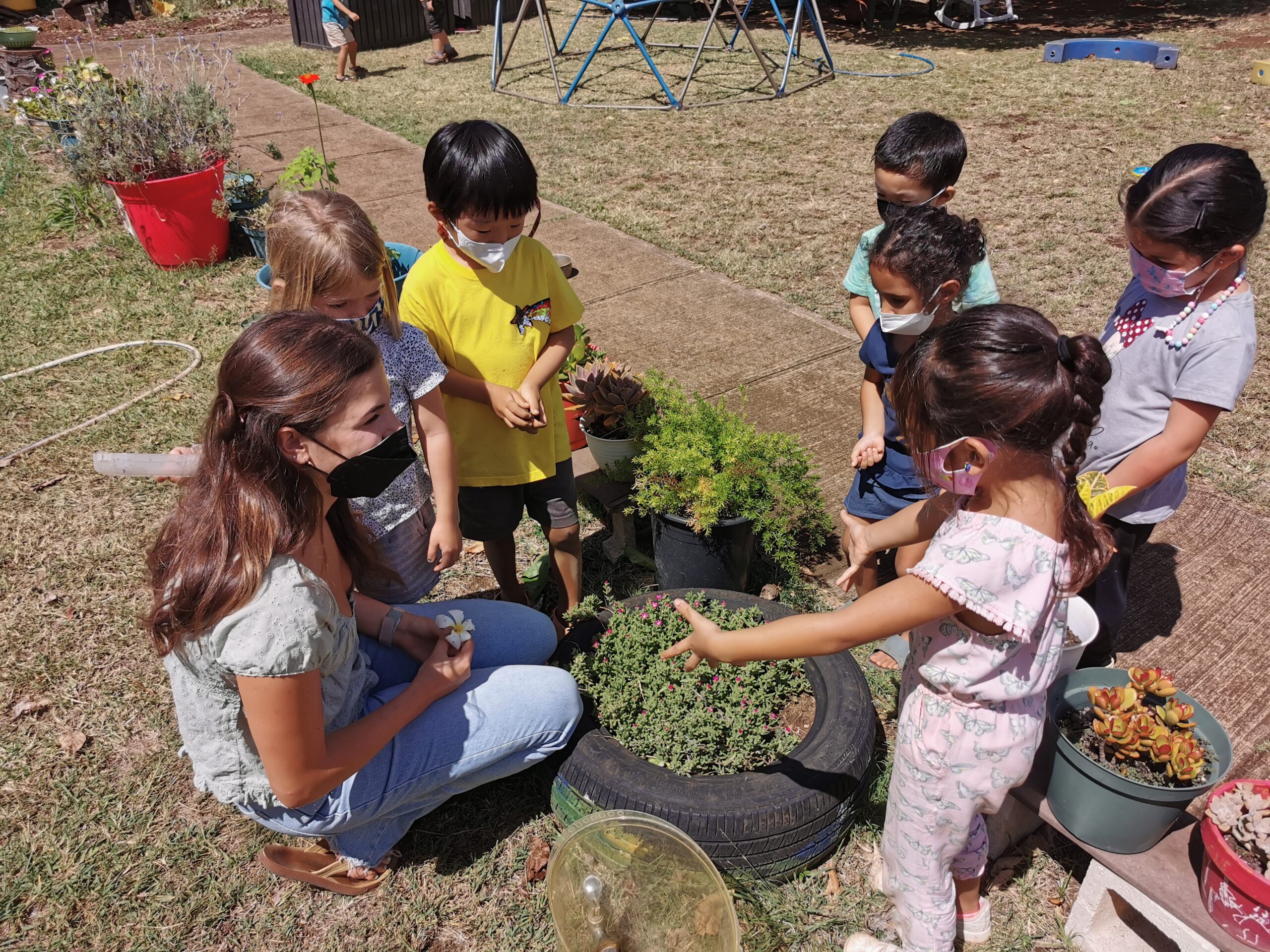 Early educator having a discussion with a group of children at the UH Mānoa Children’s Center