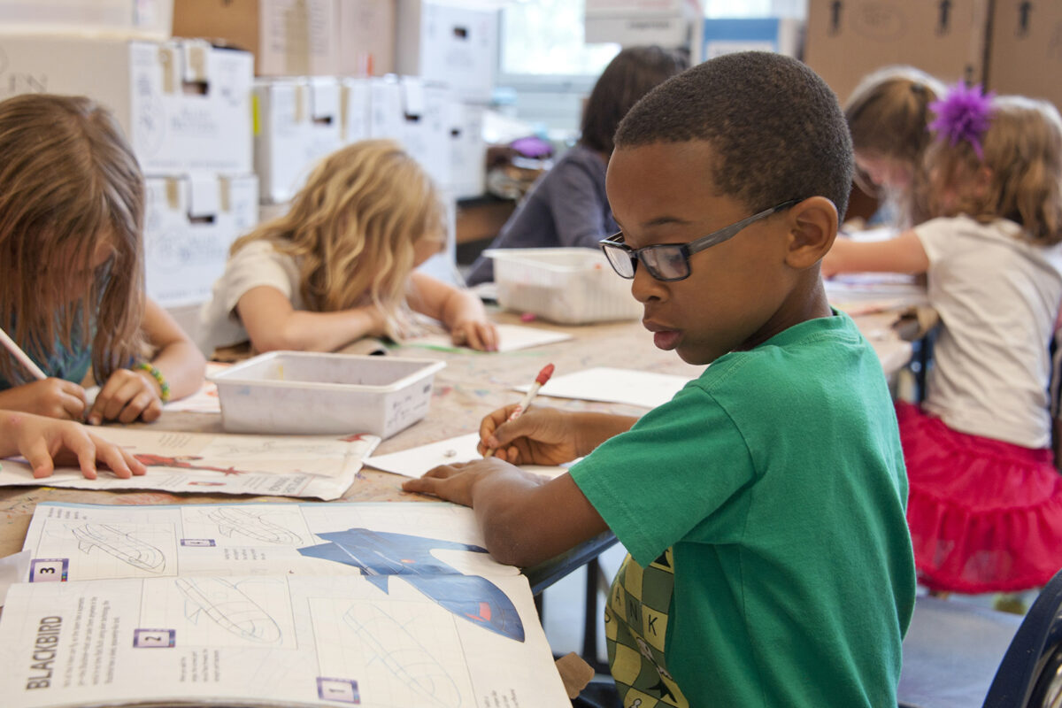 boy in classroom looking at book