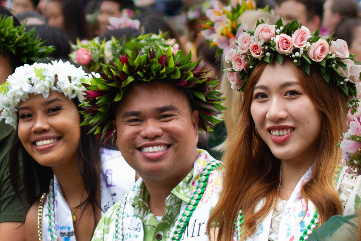 students sitting at graduations with lei po‘o