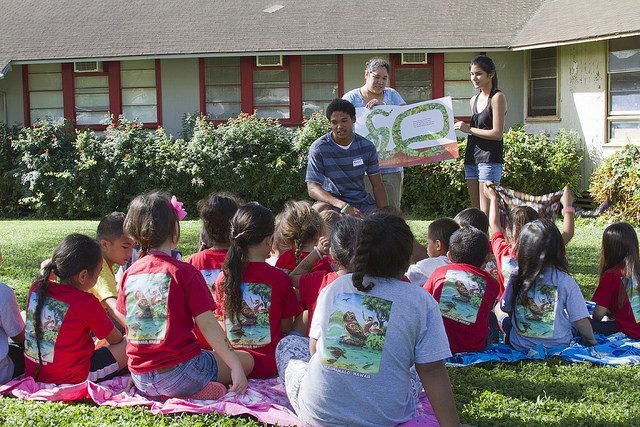 Teachers reading to a group of students