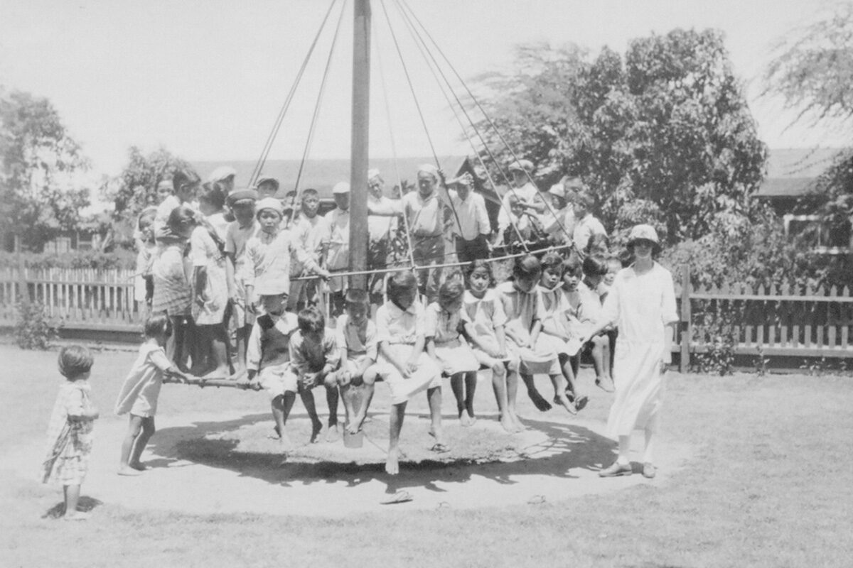 children in the playground with teacher