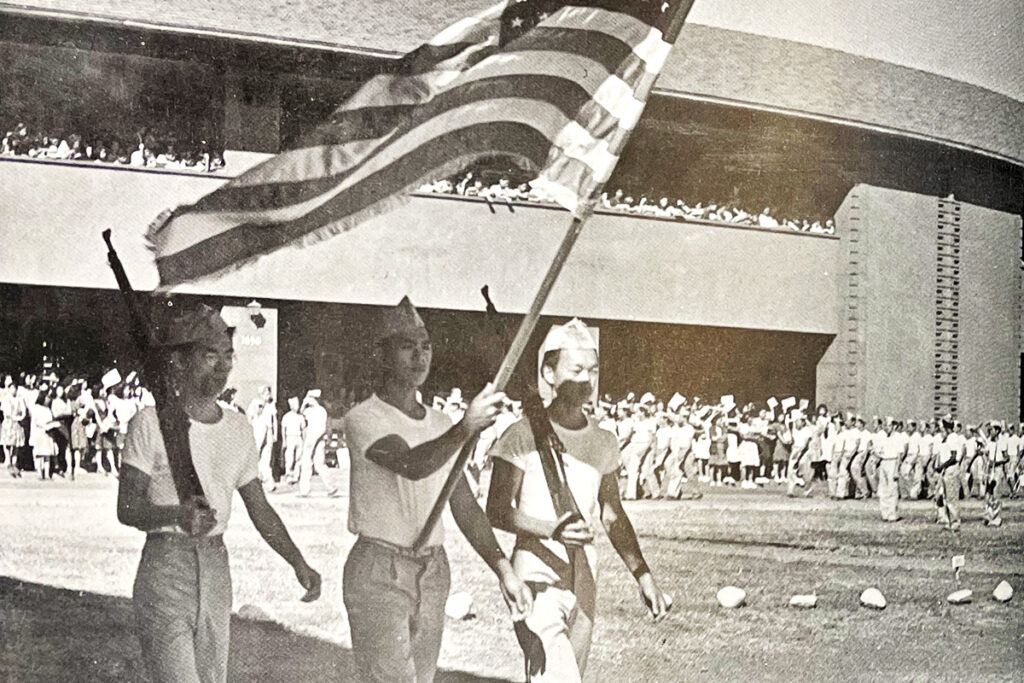 3 JROTC males waving American flag
