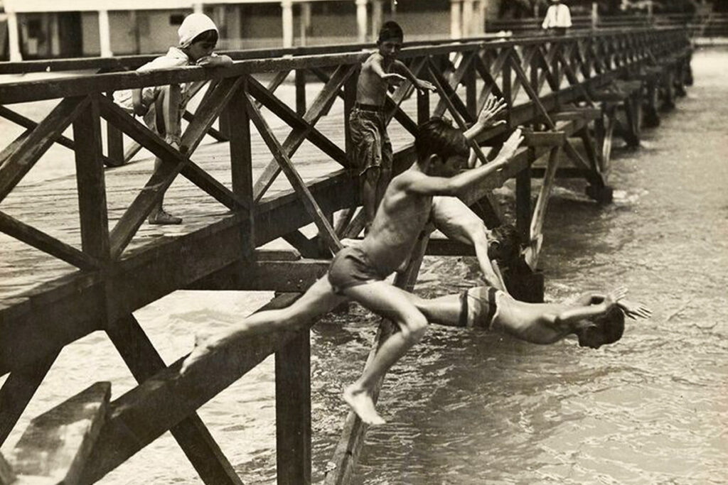 children jumping off pier