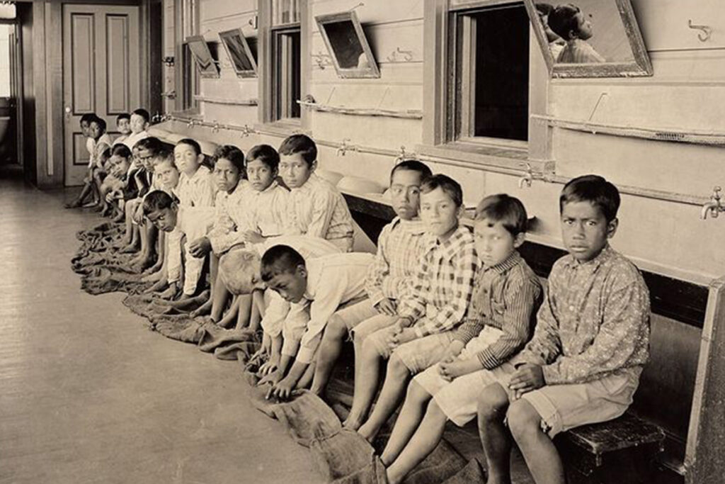 school aged boys sitting outside their classroom